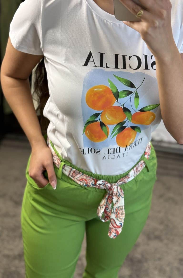 Női fehér póló mandarin grafikával, zöld nadrággal.