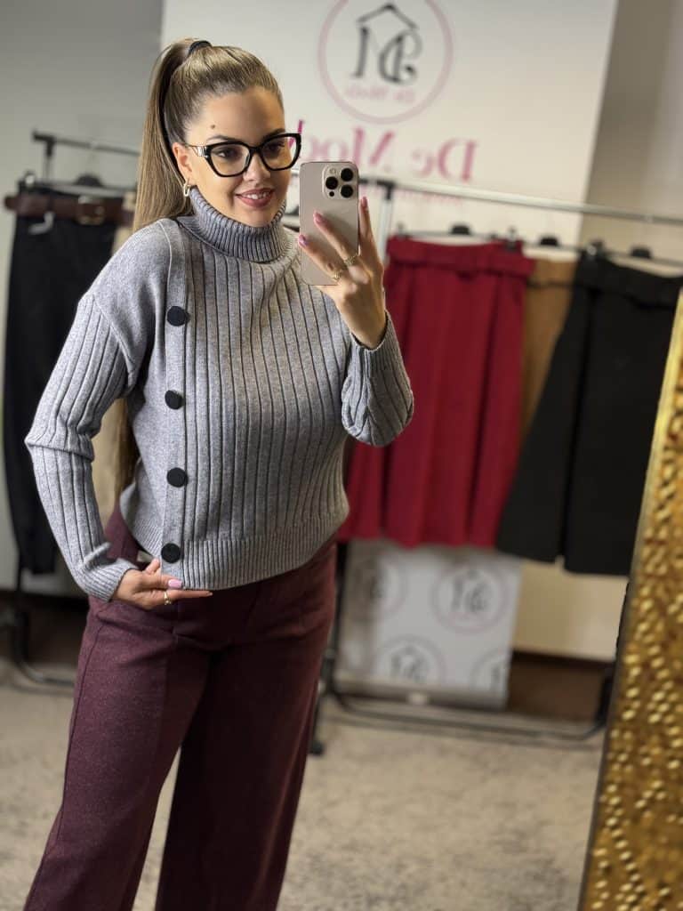 Női modell szürke kötött garbós pulóvert visel, fényképez selfie-t.