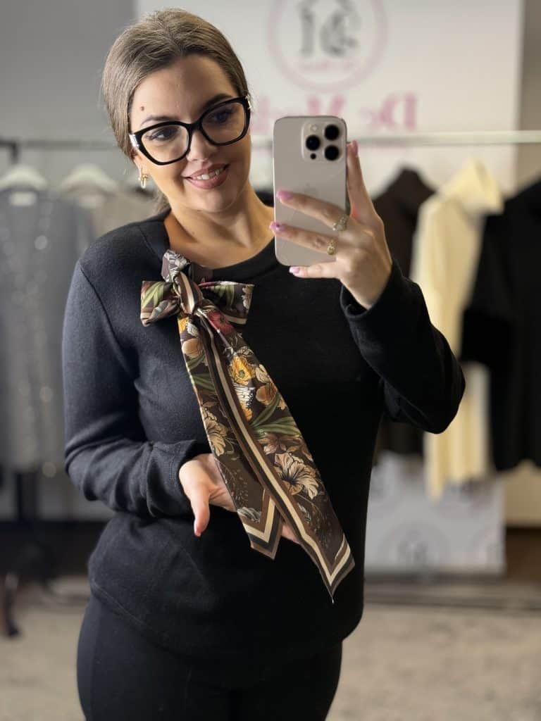 Női modell fekete felső sállal, szemüvegben, selfie fotó.
