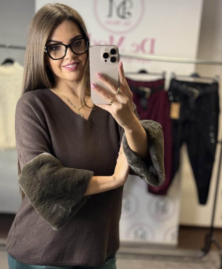 Női modell szőrmés ujjal-csokibarna felsővel a boltban.