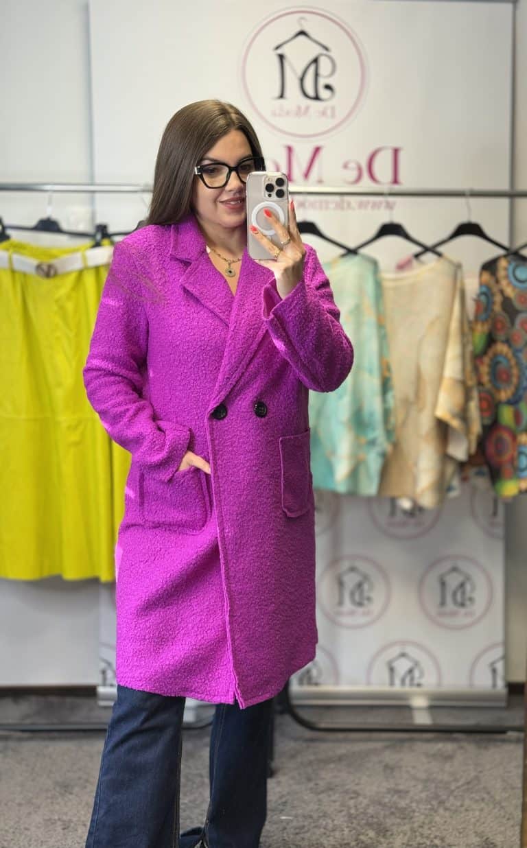 Női modell fukszia színű elegáns kabátban, fotózás közben.