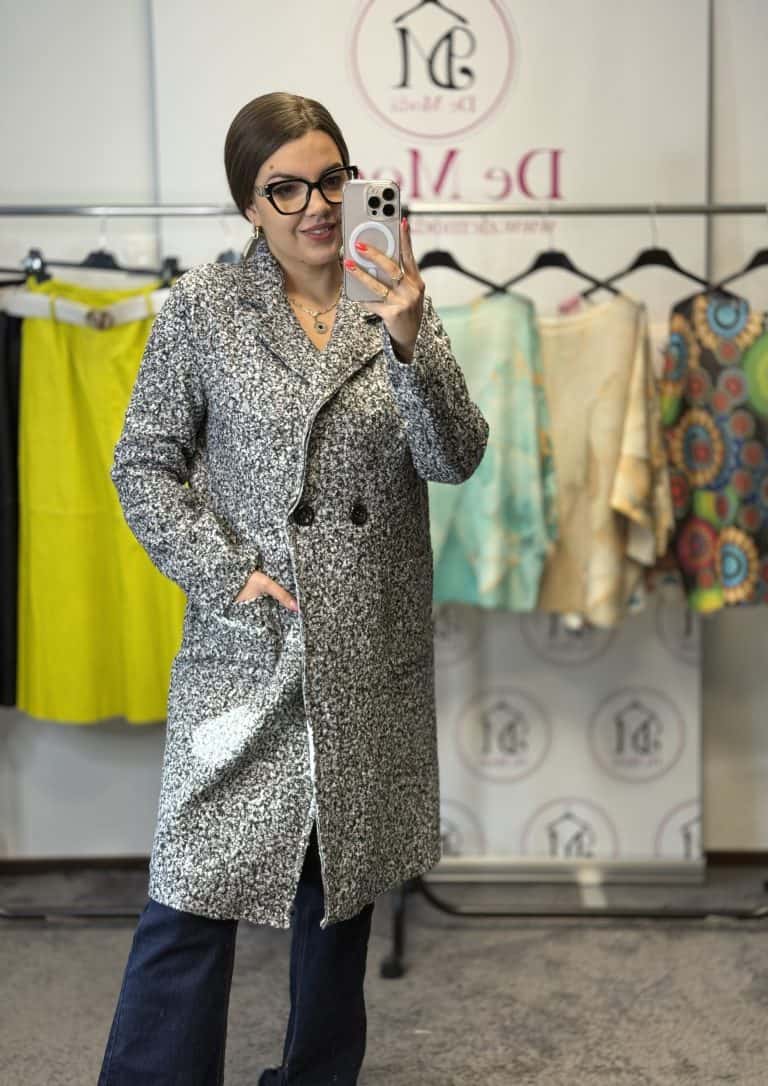 Női modell szürke elegáns/sportos kabátban, hátul a próbafülkében.