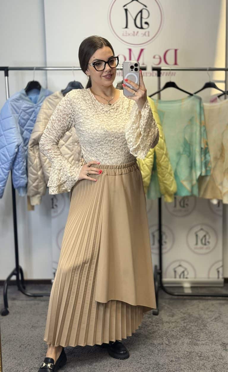 Női modell próbál egy elegáns beige színű ruhát.