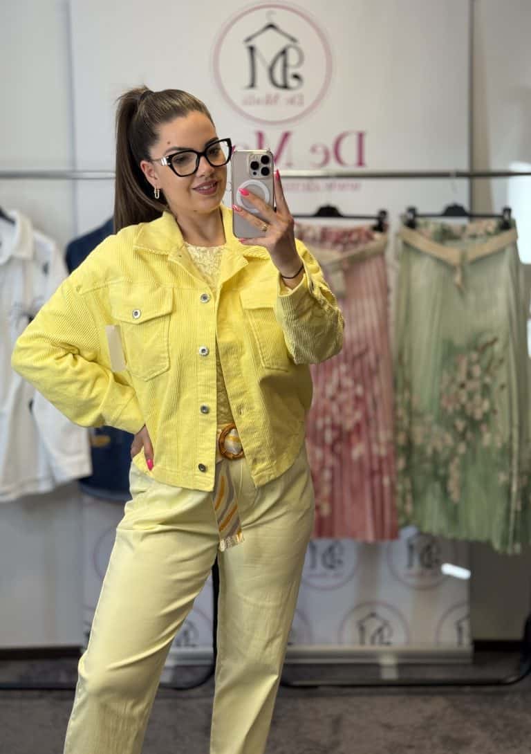 Női modell kordbársony sárga kabátban, tükörkép selfie készítése.