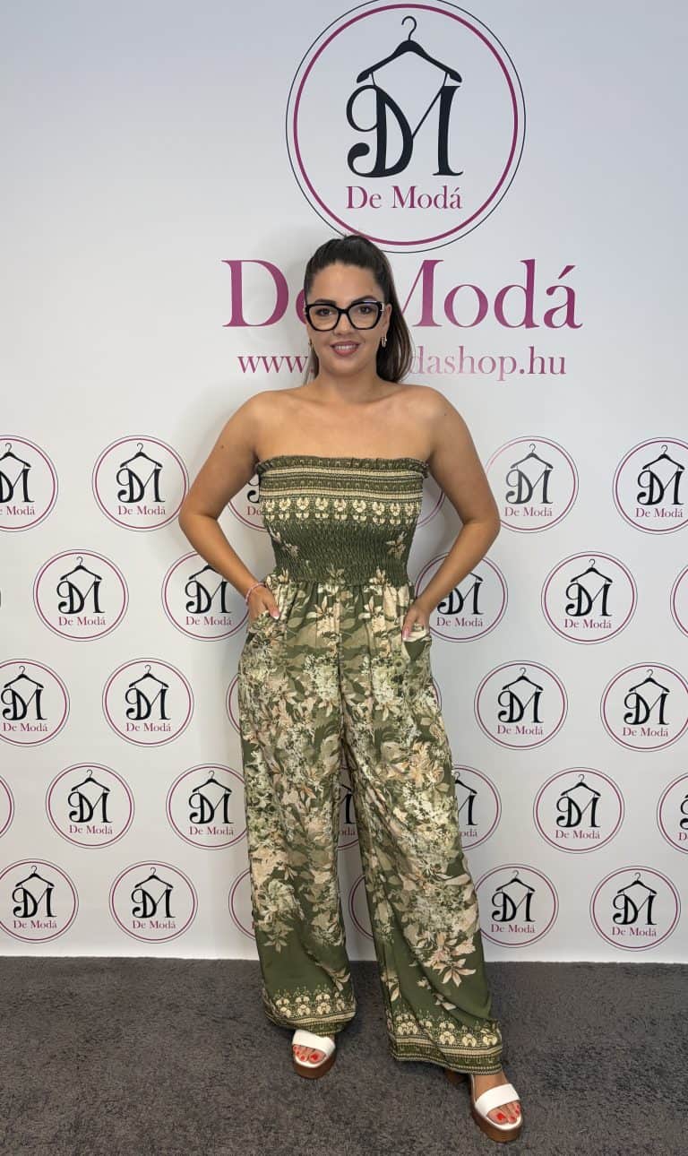Női modell virágos mintázatú overálban, keki színben, hátul gumis rész.
