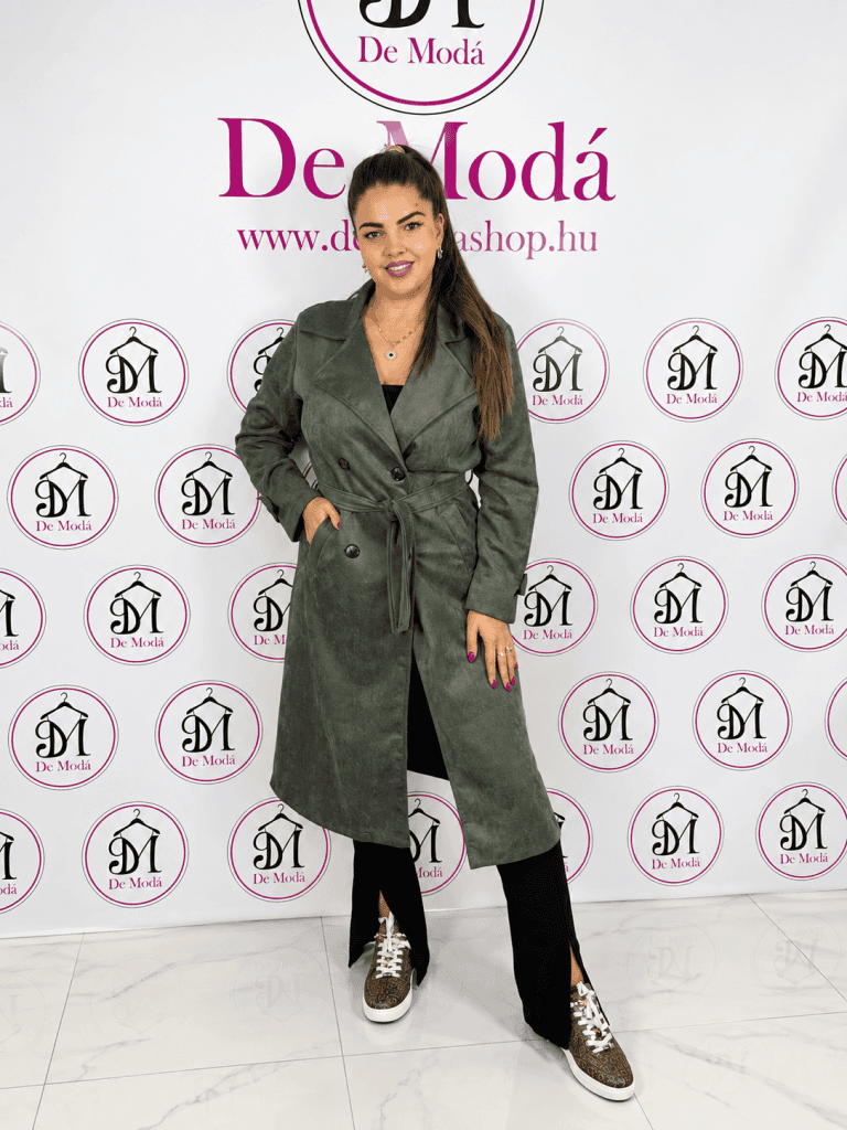 Női modell keki színű velúr hatású kabátban, háttérben De Moda logóval.