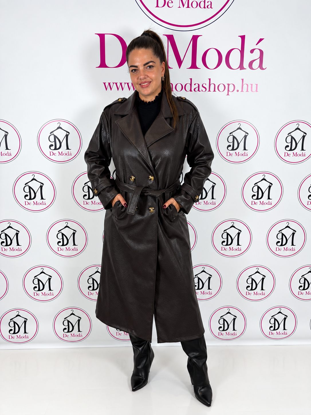 Női modell fekete bőrkabátban, háttérben a De Moda logóival.