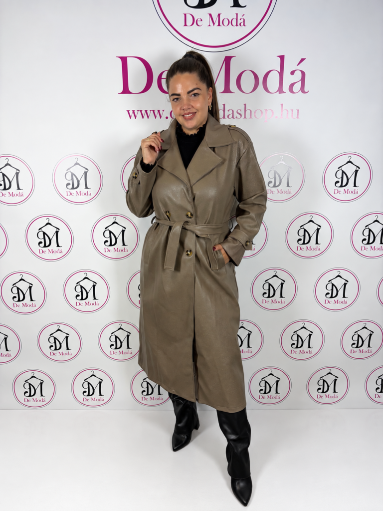 Nő modell hosszú műbőr kabátban, háttérben a De Moda logóval.